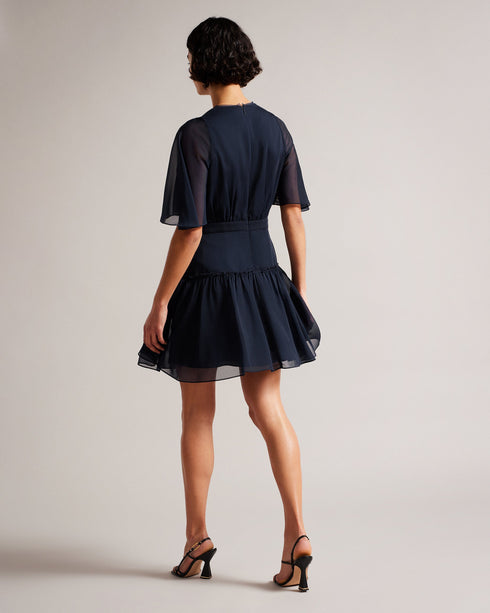 GIGGIE-Dresses-Add a touch of retro style to your wardrobe with GIGGIE. This dress features a fit and flare silhouette, with sheer fluted sleeves and a ruffle tiered skirt that are sure to make you stand out at your next event.The shell of this product is made of 100% recycled polyester. Using recycled polyester helps divert plastic waste from ending in landfills and helps us to reduce our dependency on virgin materials. Mini dress Tiered skirt with ruffles Fit and flare Sheer fluted sleeves Neck tie V neck